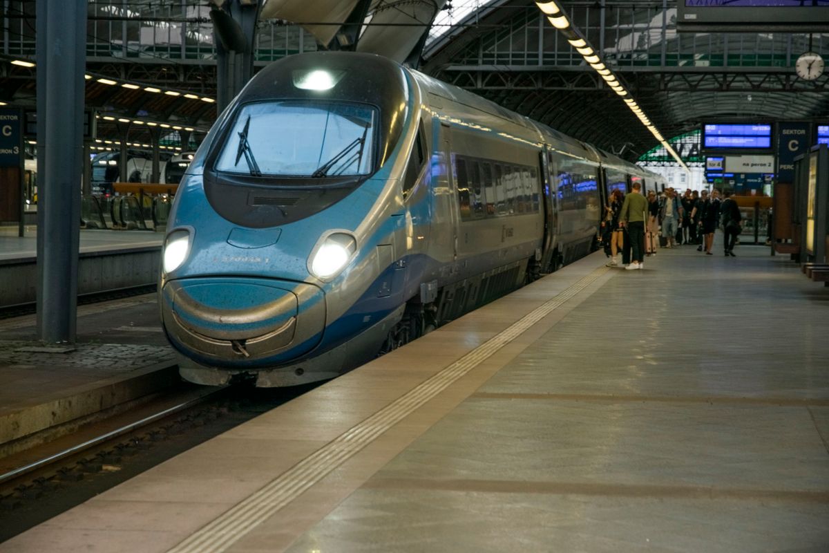 Tren de mare viteză cu botul albastru oprit la peron într-o gară din Wrocław, cu călători urcând