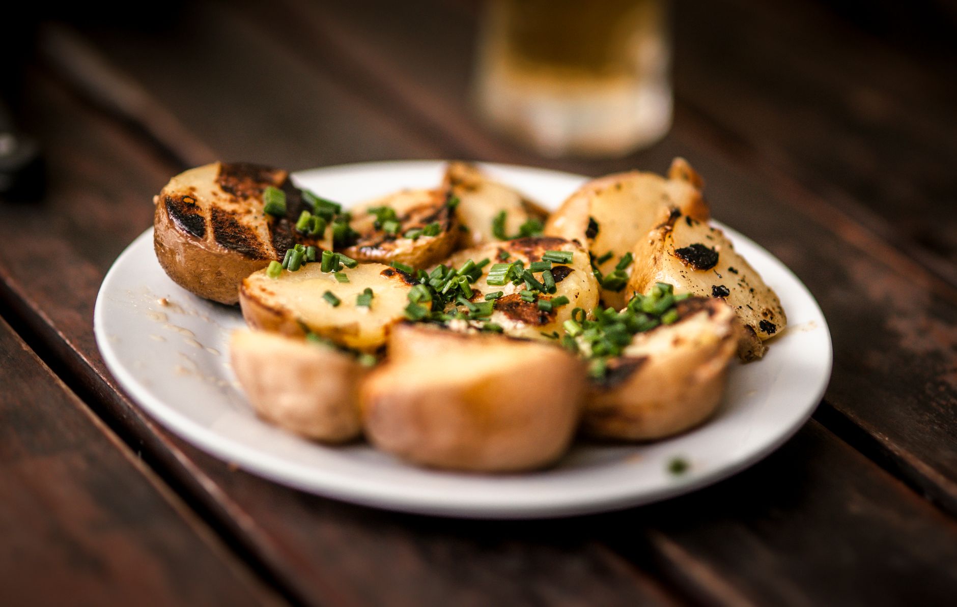 Crispy Hasselback Potatoes: The Ultimate Holiday Side Delicious grilled potatoes garnished with fresh chives, perfect for a rustic meal.