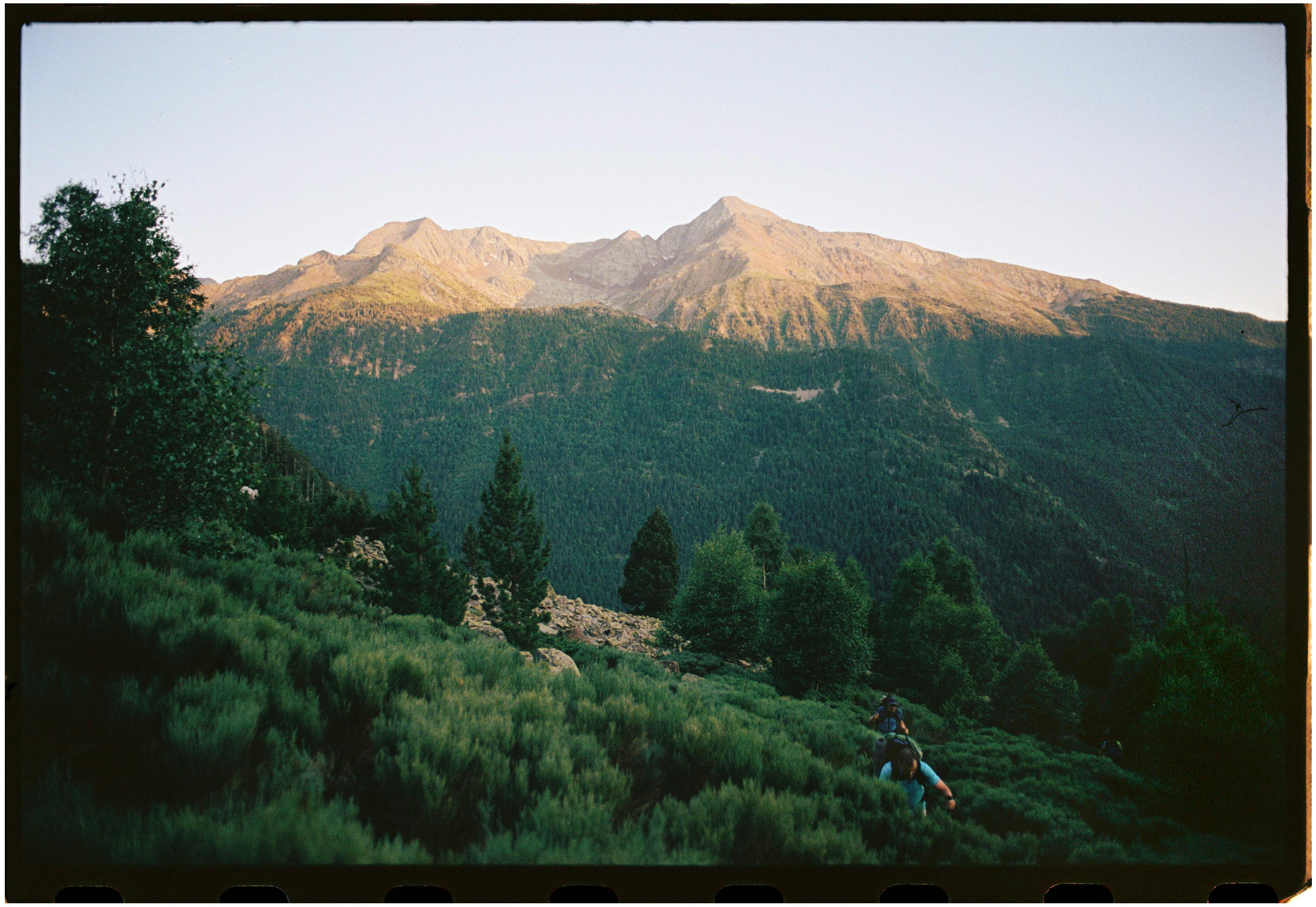 a person is walking on a trail in the mountains