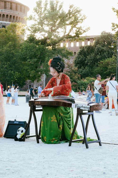 Music Instruments In Rome A woman playing a musical instrument in front of the roman colosseum ...
