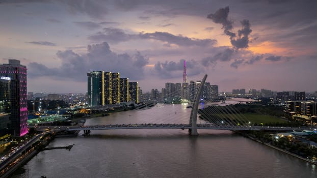 A breathtaking view of Ho Chi Minh City skyline during sunset with a river and bridge.