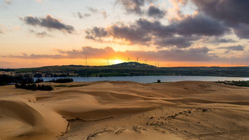 Free Stunning sunset view over sand dunes and wind turbines in Phan Thiet, Vietnam. Stock Photo