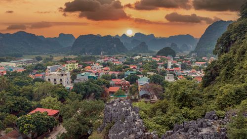 Free Beautiful landscape of Ninh Bình with mountains and colorful town at sunset. Stock Photo