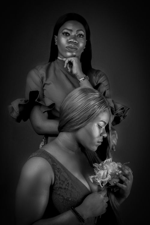 Free Black and white studio portrait showcasing elegance and grace of two women with roses. Stock Photo