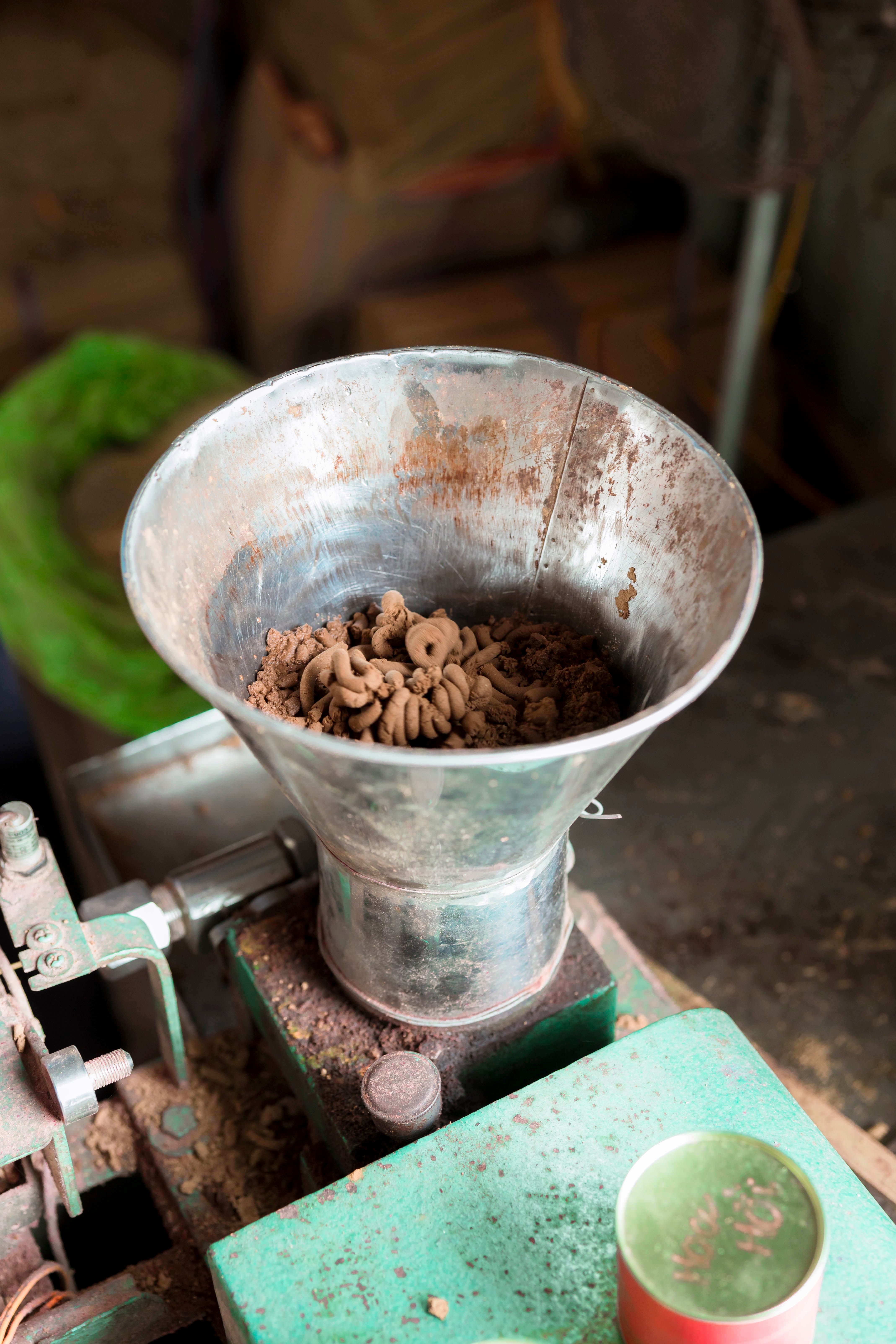 Vintage coffee grinder at work grinding beans in a rustic setting.