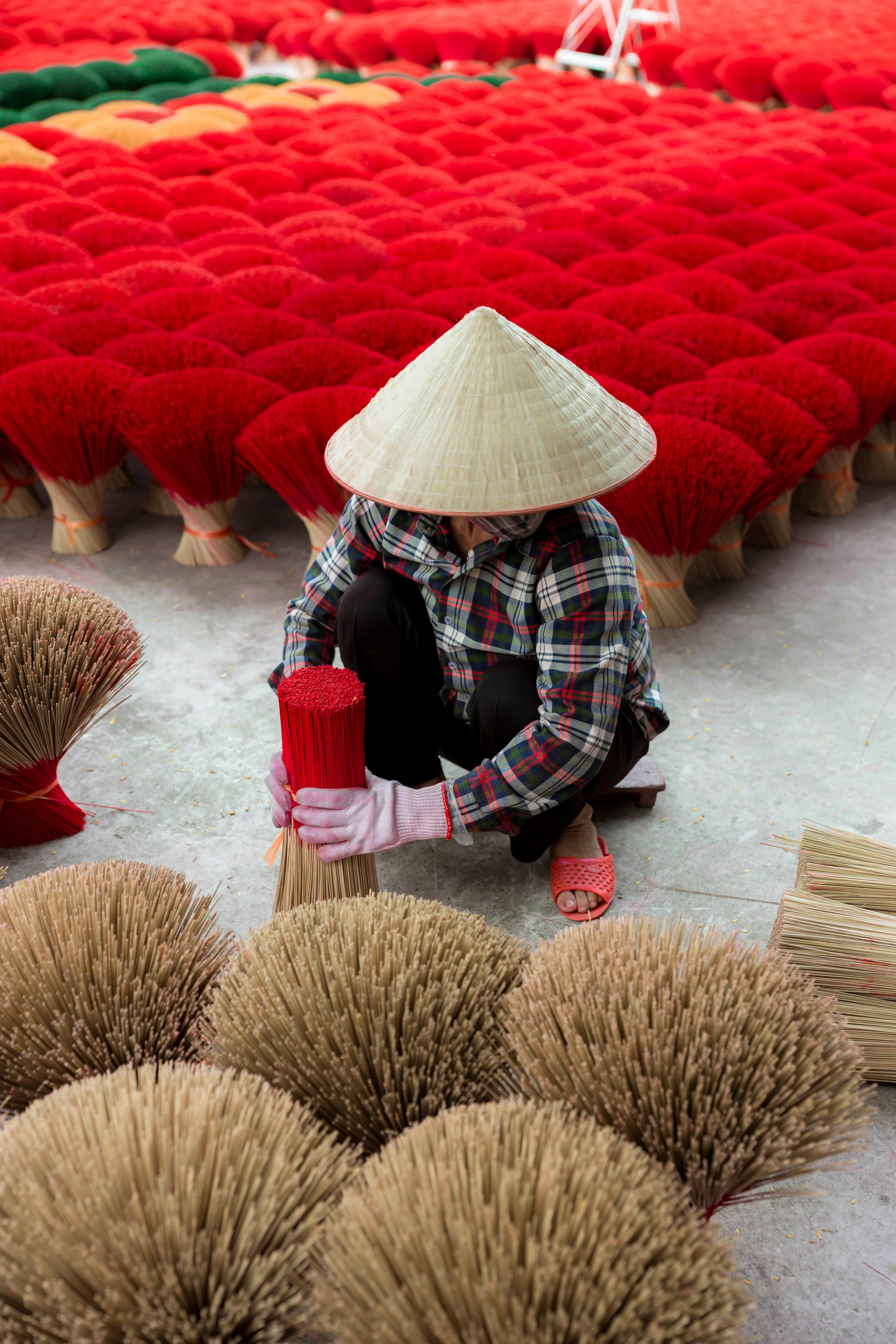 a woman is kneeling down in front of a bunch of straws