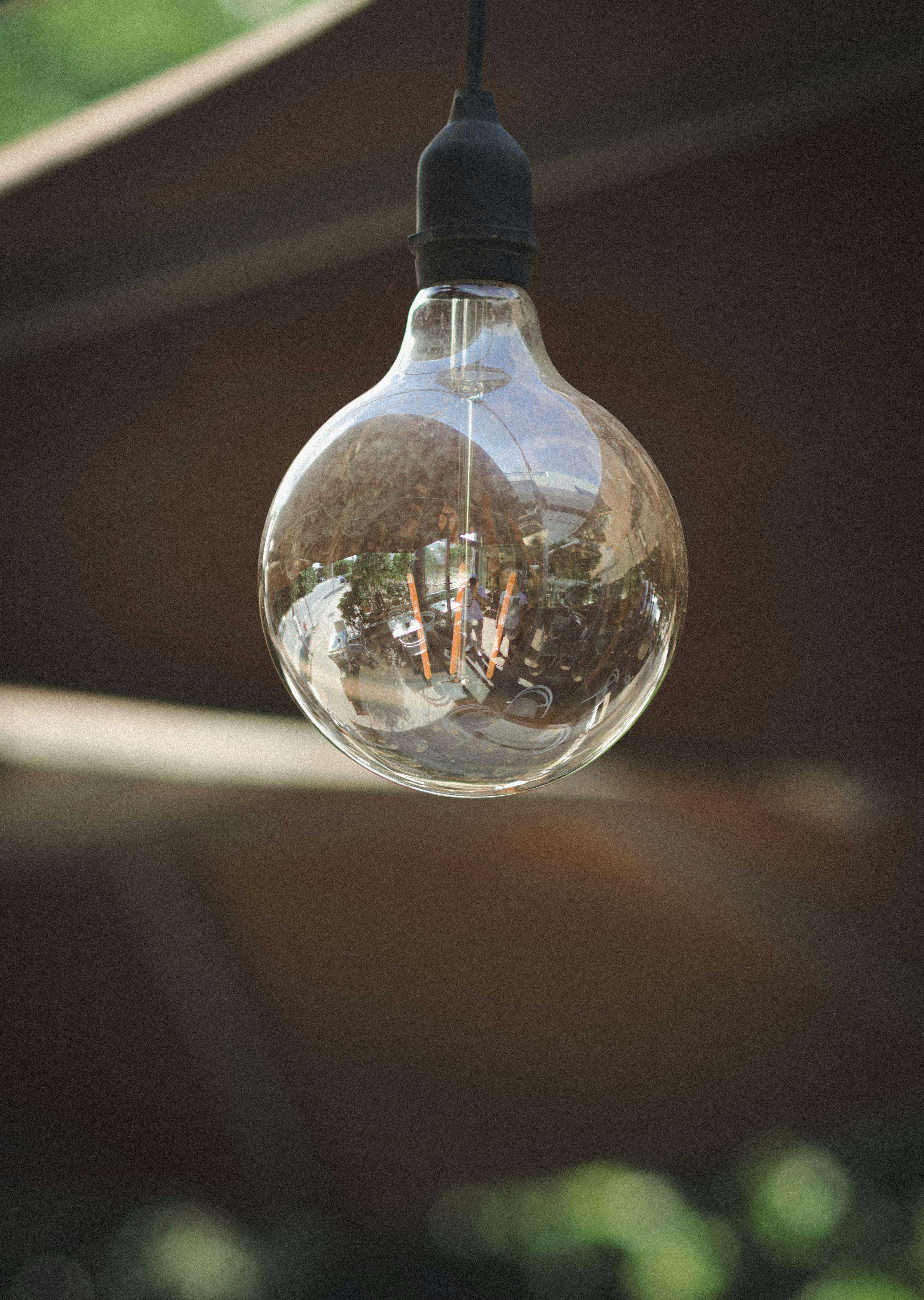 Close-up of vintage lightbulb outdoors in Carthage. Reflection captures outdoor ambiance.