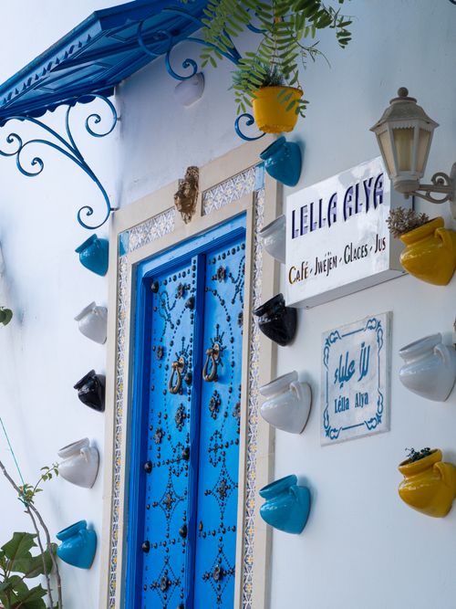 Free Colorful Tunisois-style door with pottery and plants in Carthage, Tunisia. Stock Photo