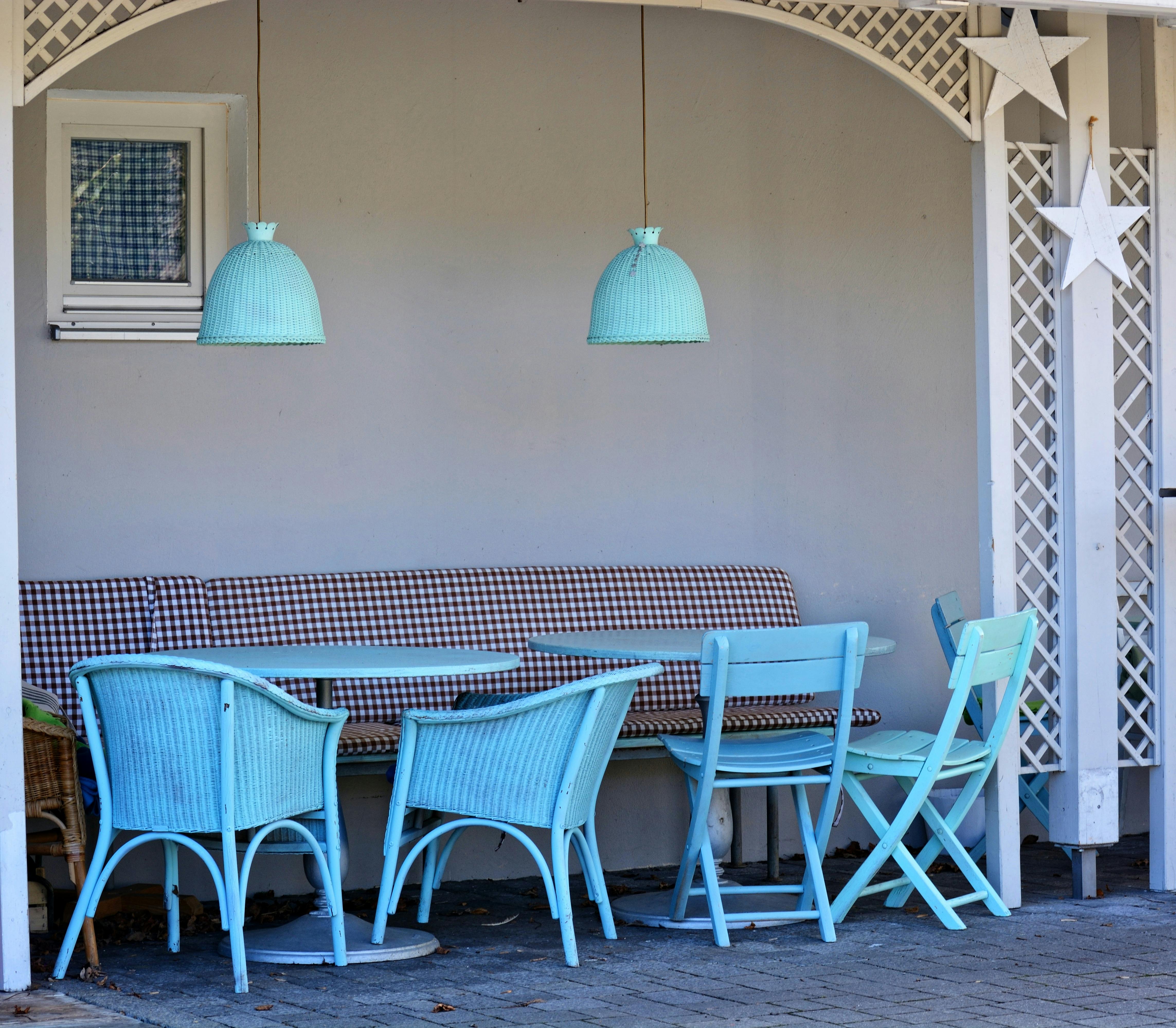 Free Stylish outdoor seating area with blue chairs and tables under lamps. Stock Photo