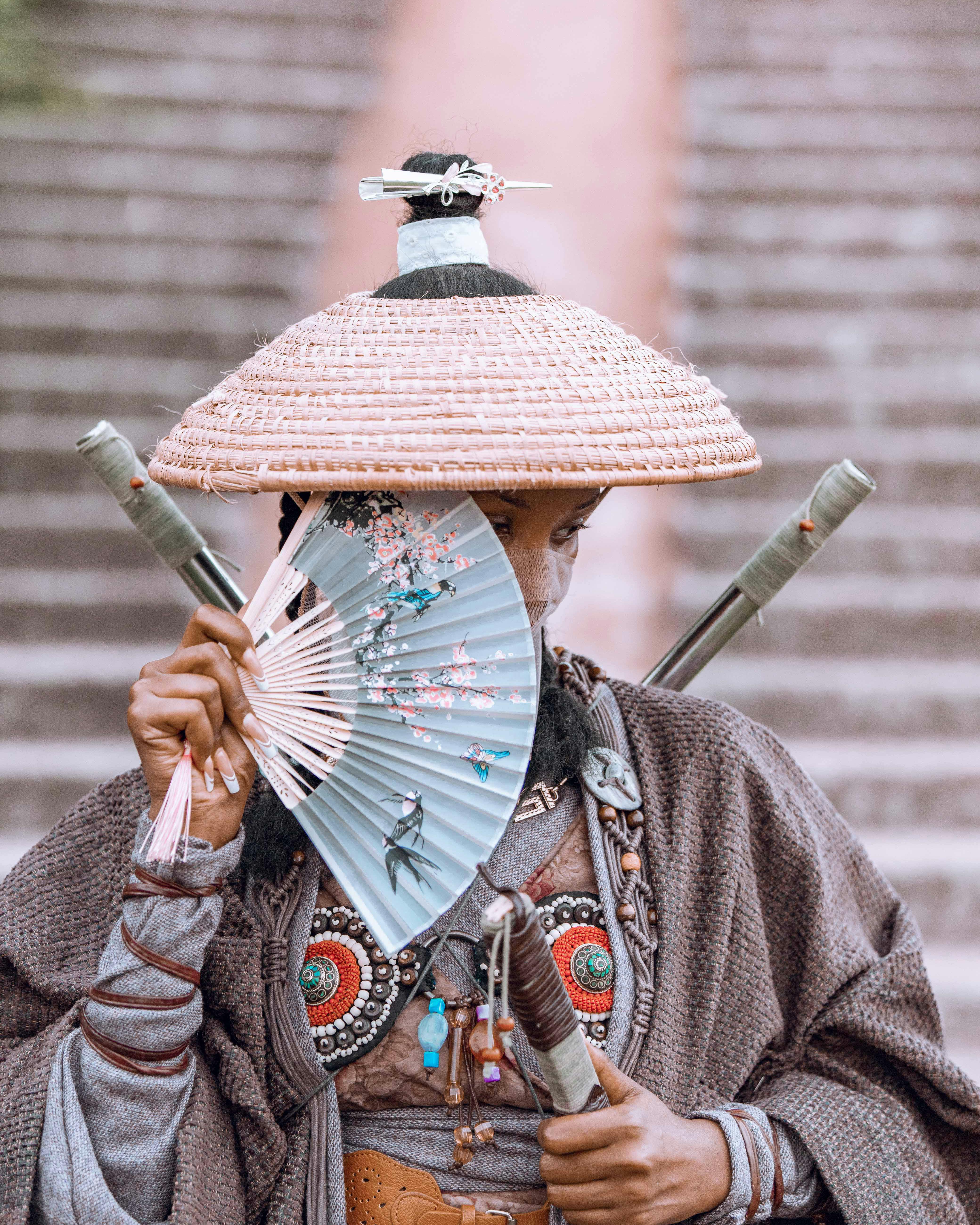 a woman in traditional clothing holding a fan