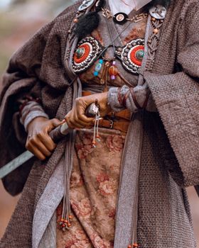 Close-up of traditional attire with intricate beadwork and sword, depicting cultural richness and history.