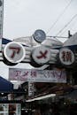 A sign with japanese writing on it in front of a market