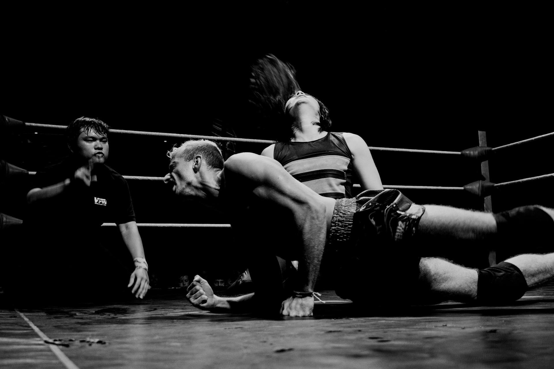 A black and white photo of a wrestler on the ground