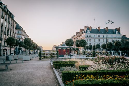 Free Peaceful city square in Rennes, France with beautiful architecture and greenery at sunset. Stock Photo