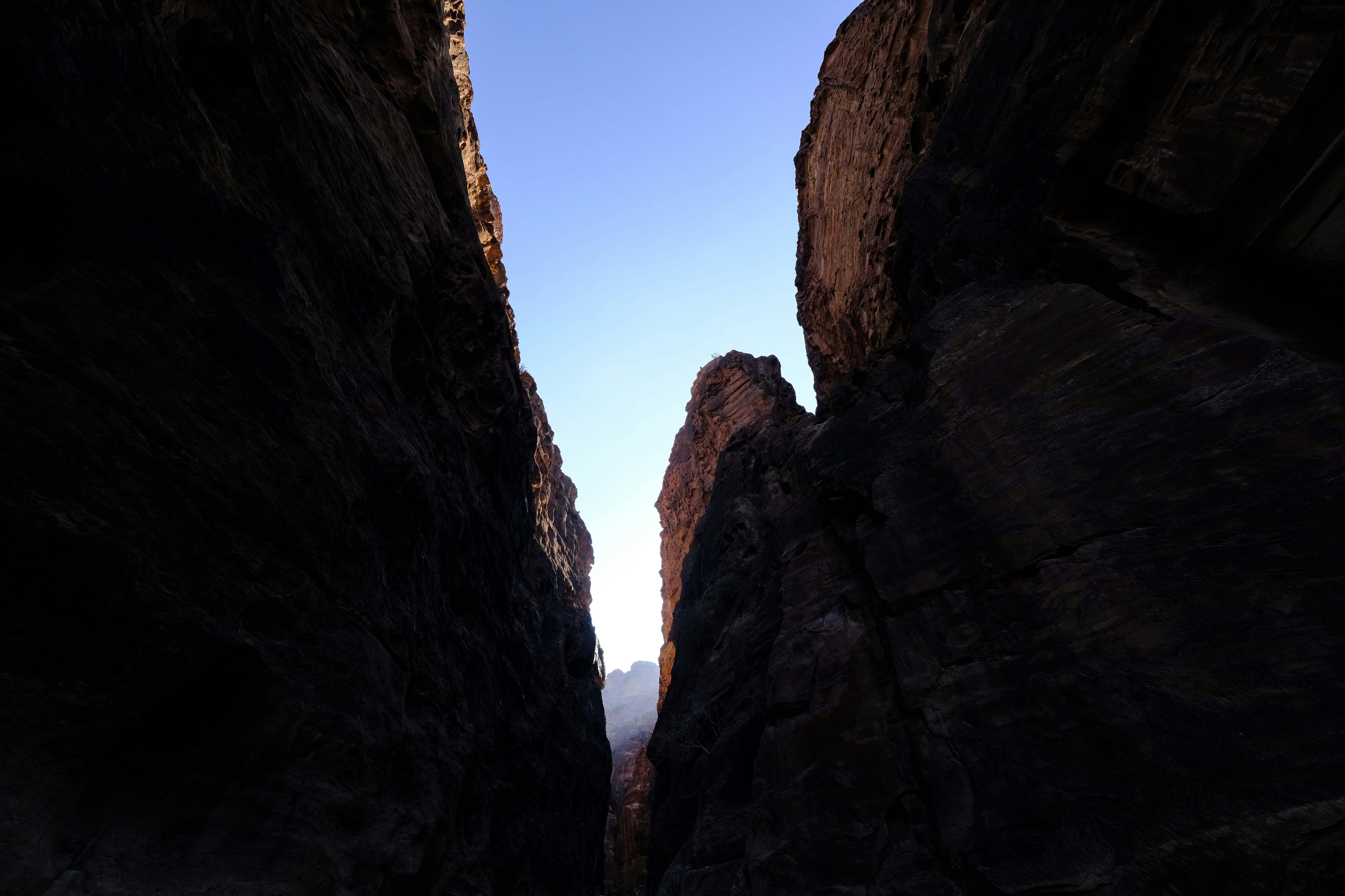 the sun shines through a narrow canyon