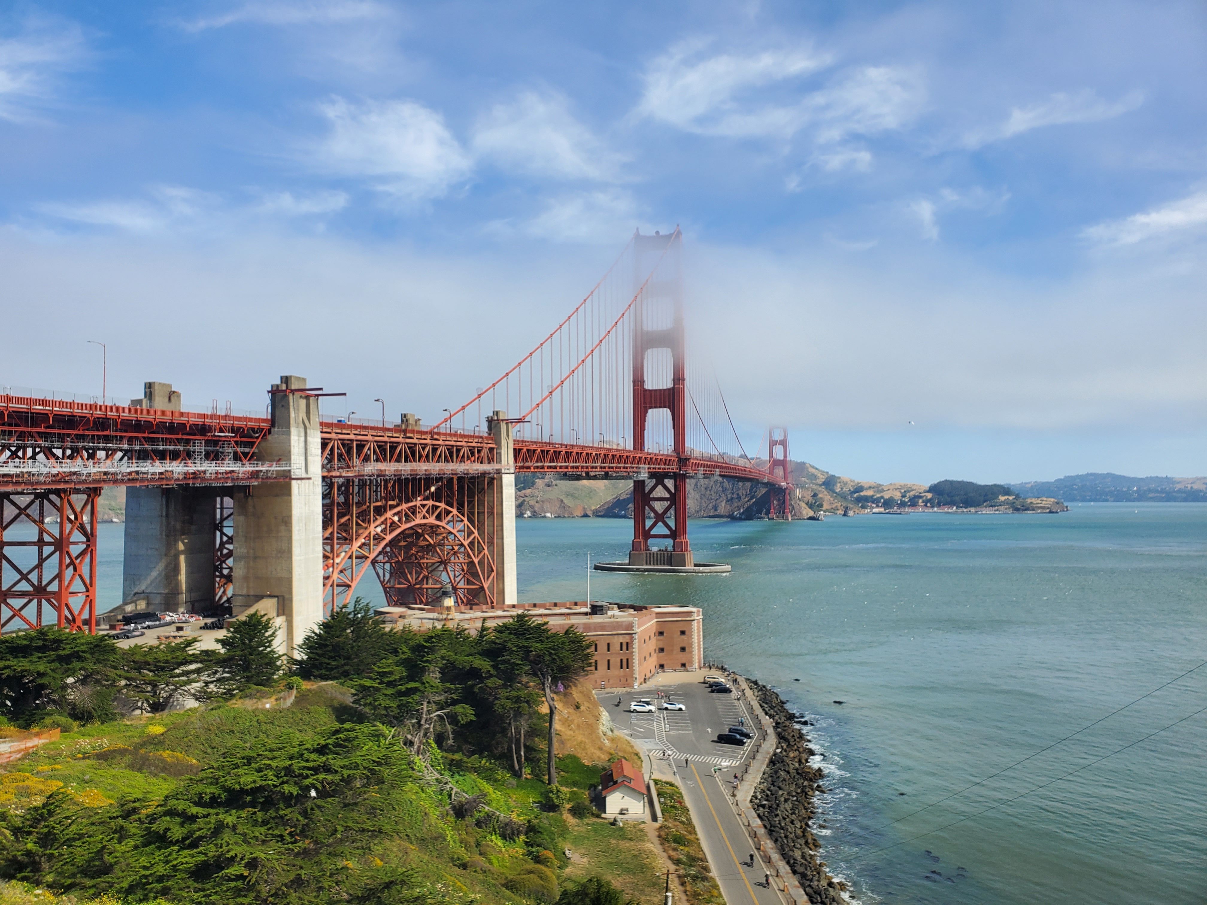Free Iconic view of the Golden Gate Bridge shrouded in summer fog with a scenic bay backdrop. Stock Photo