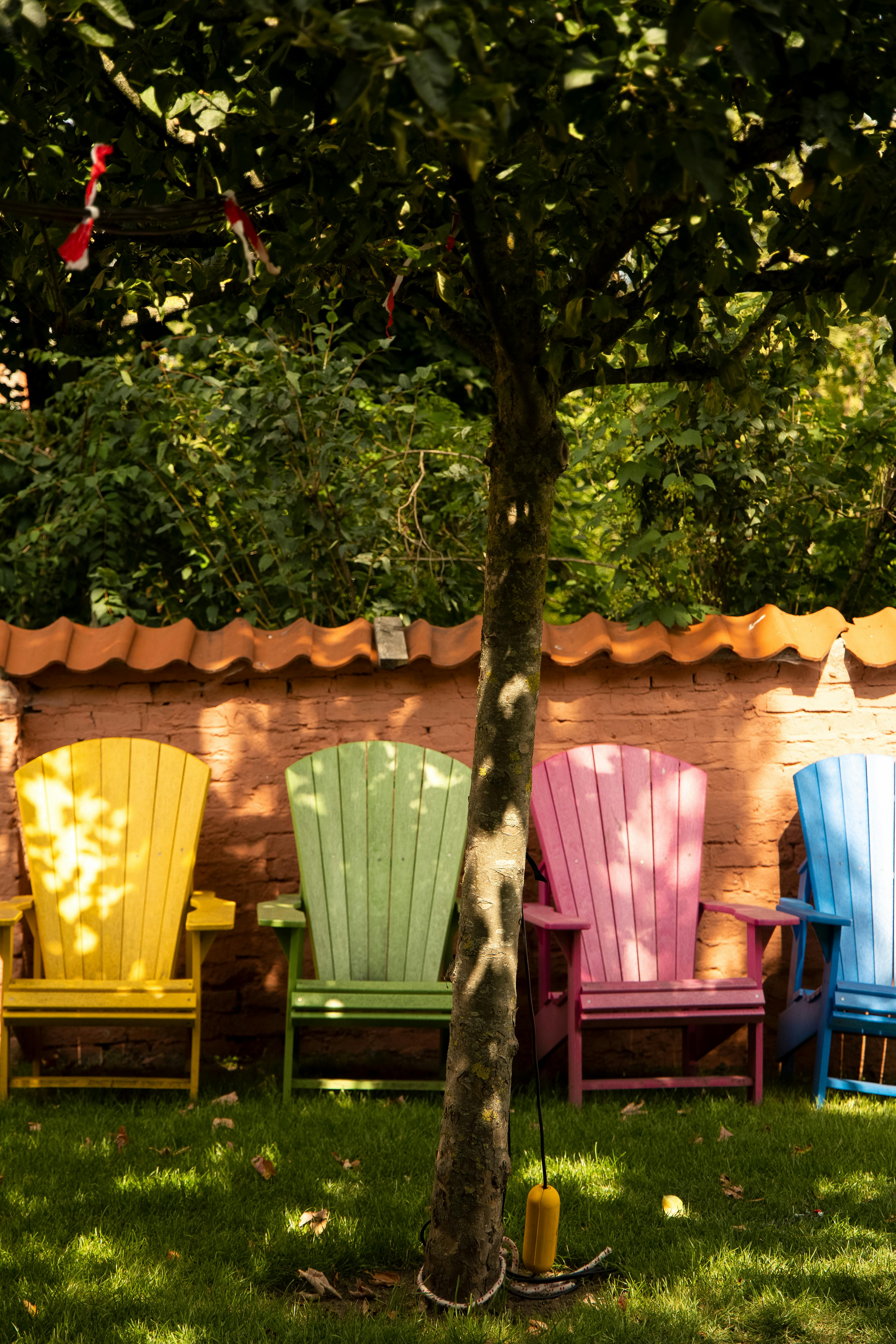Vibrant garden chairs in Lübeck, Germany with tree shade, perfect for summer relaxation.