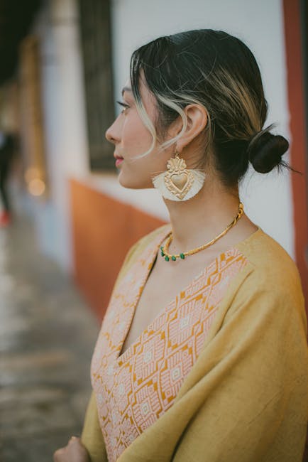 Side view of a woman wearing traditional jewelry and clothing outdoors.