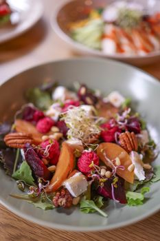 Vibrant mixed salad with fruits, nuts, and cheese, perfect for a healthy meal.