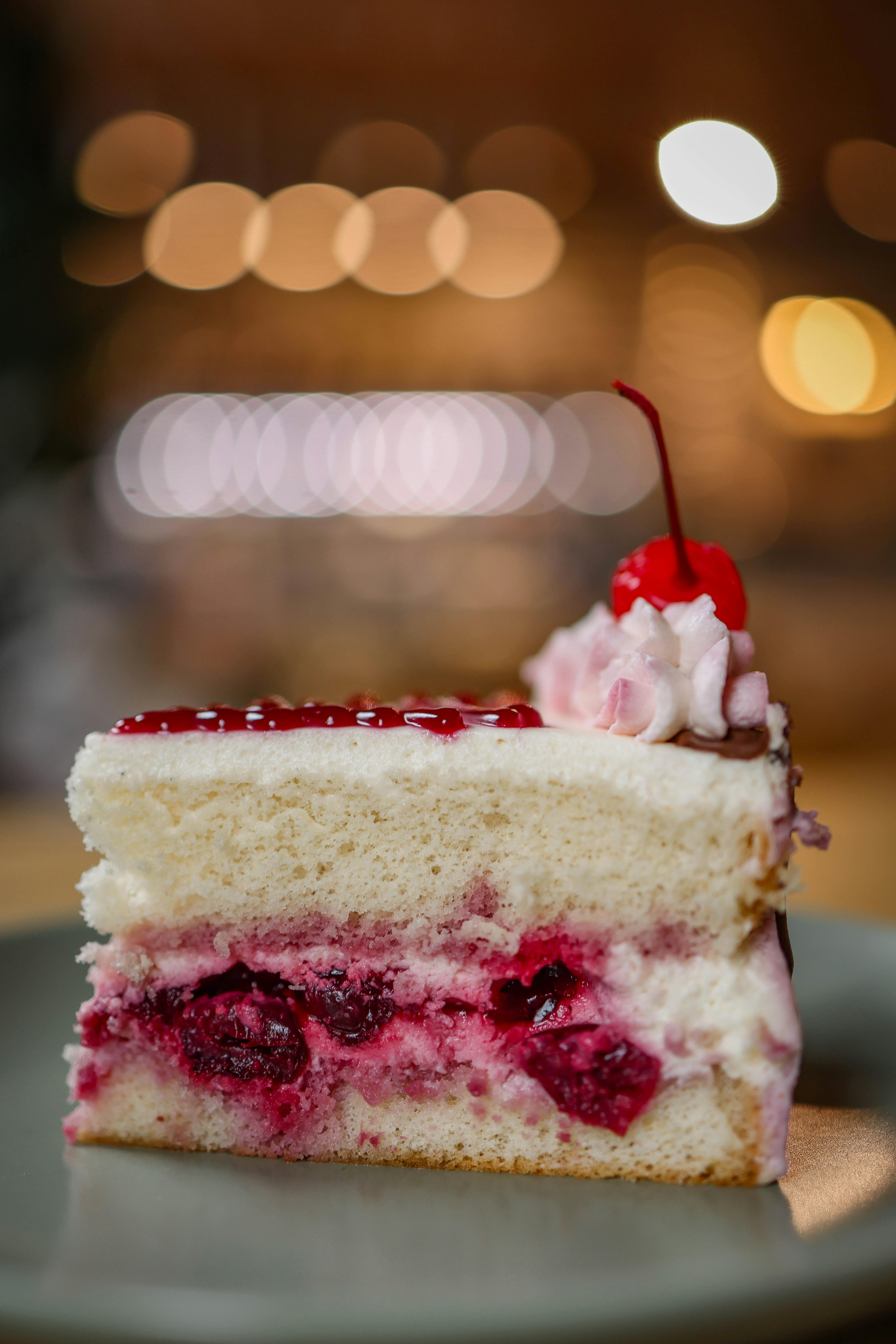 Enticing slice of cake with cherries, cream, and layers - perfect for dessert lovers.
