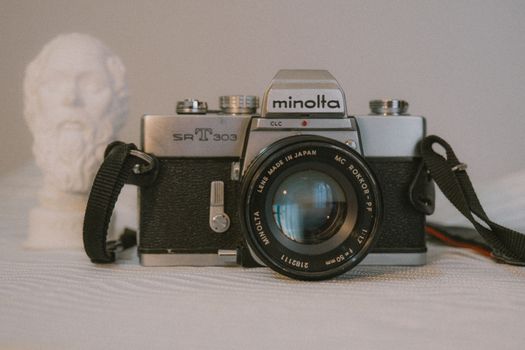 A classic Minolta SRT 303 camera with a bust, showcasing analog photography charm.