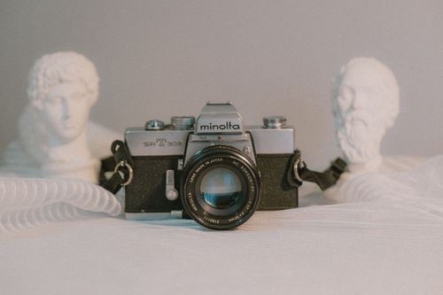 Free A classic Minolta film camera displayed with artistic sculptures in a minimalist setting. Stock Photo