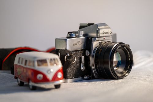 Free Close-up of a classic Minolta camera next to a miniature VW bus, evoking nostalgia and retro vibes. Stock Photo