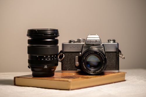 Free Classic Minolta film camera with lens displayed on a book, ideal for photography enthusiasts. Stock Photo