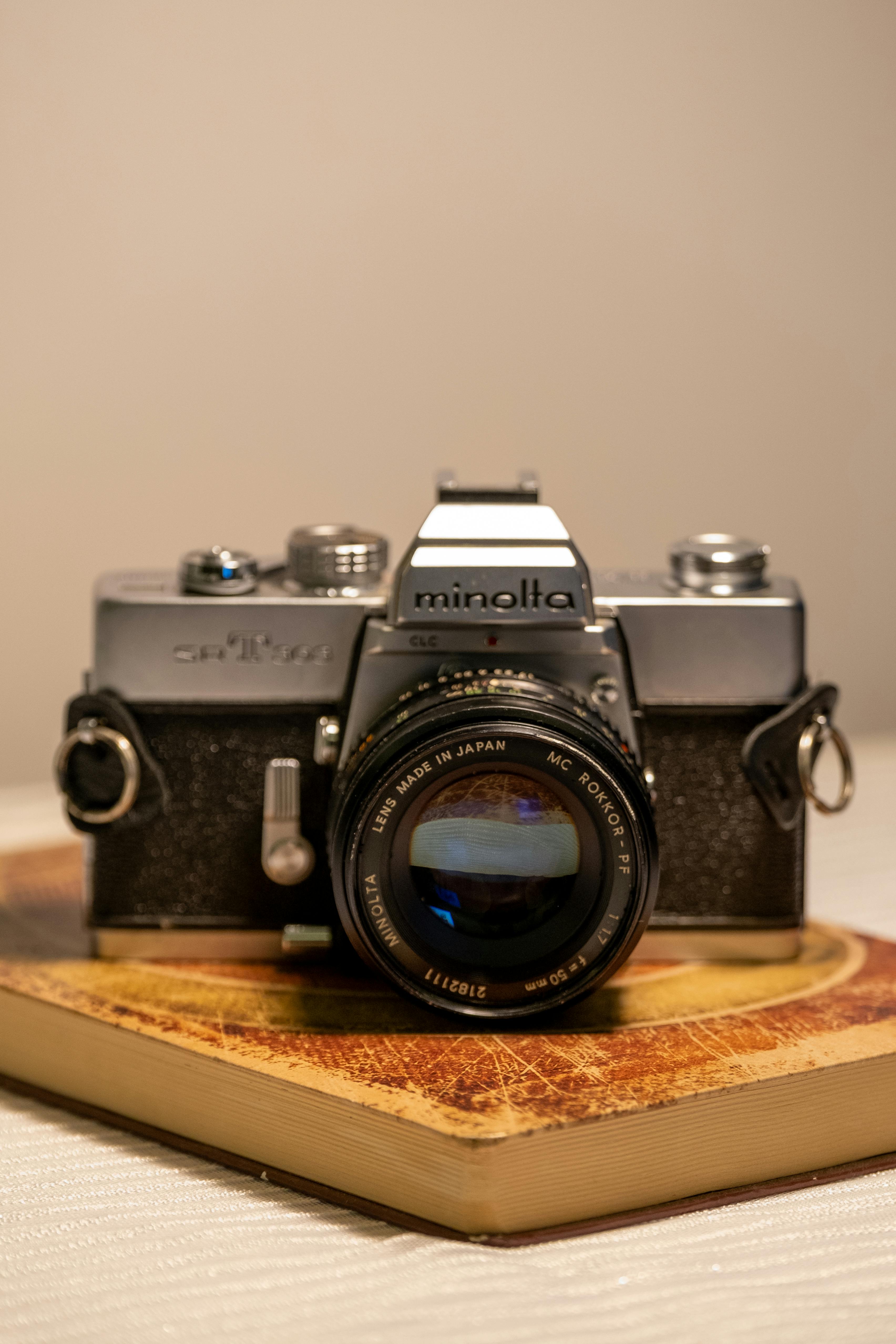 A close-up of a classic Minolta film camera with lens on a wooden stand, perfect for vintage photography enthusiasts.