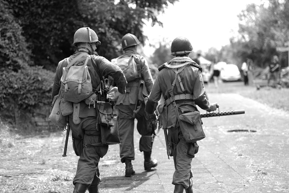 Group of soldiers in period uniforms during a historical military reenactment outdoors.