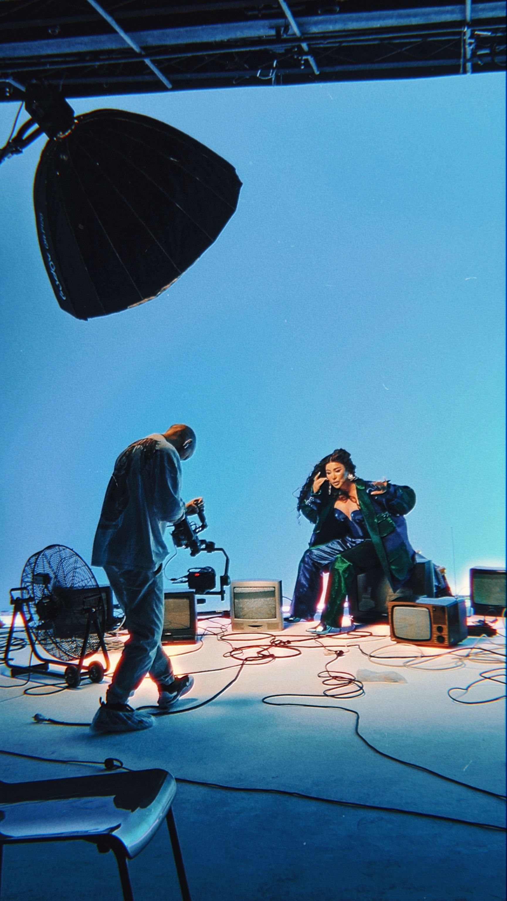 Dynamic music video shoot featuring equipment and vibrant lights in studio.