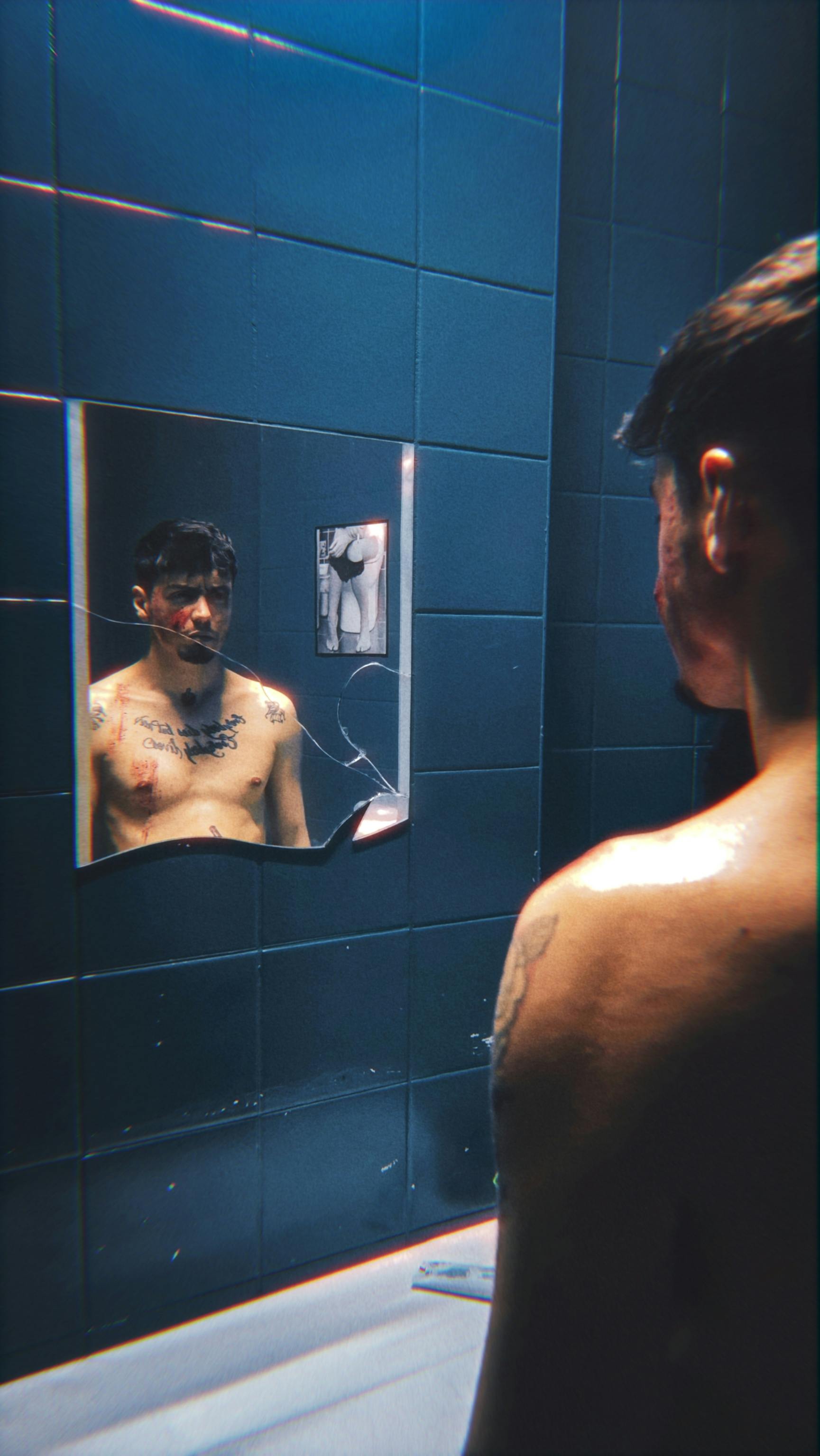 a man looking in the mirror while standing in front of a bathroom