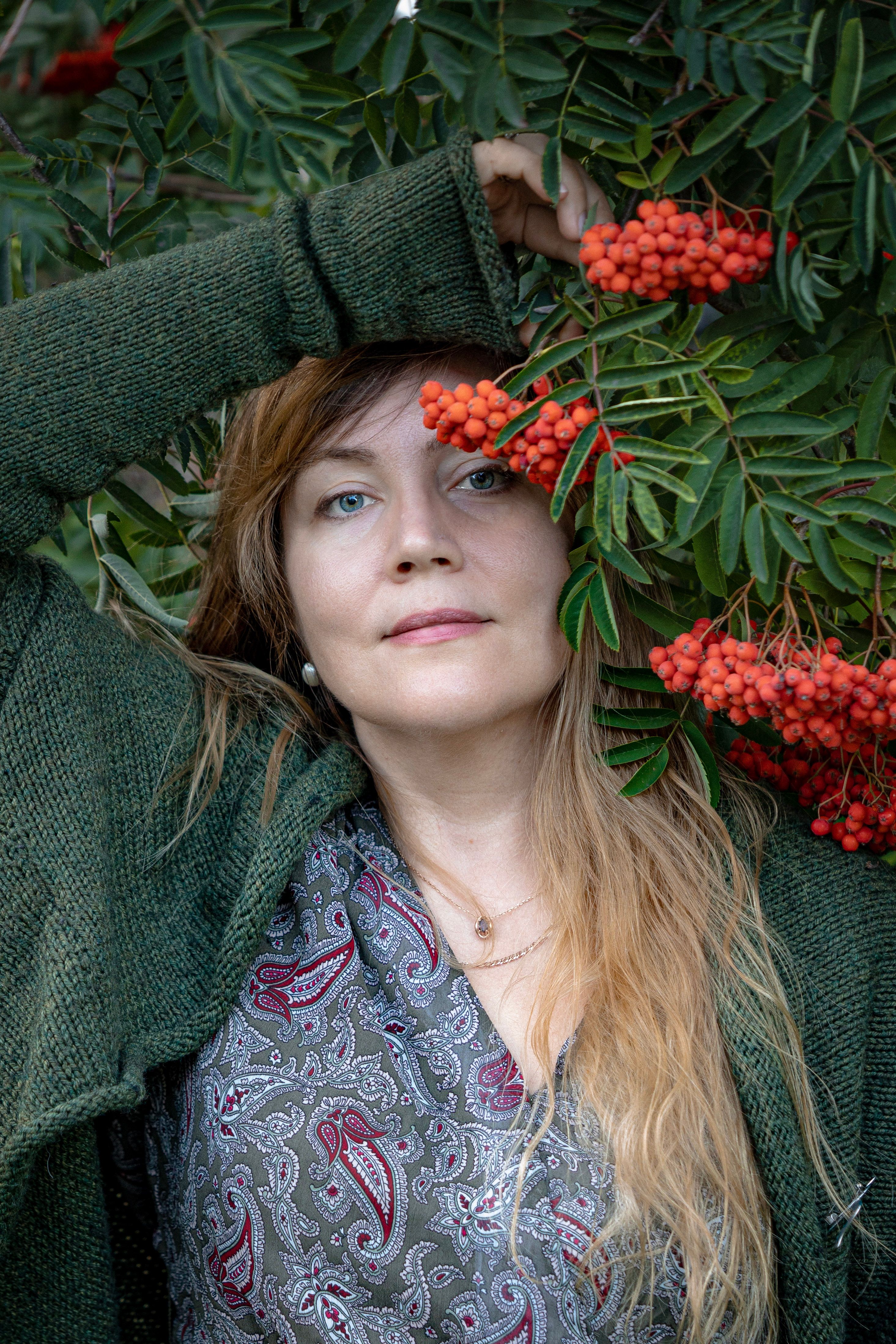 Portrait of a woman among rowan berries, exuding autumn vibes.