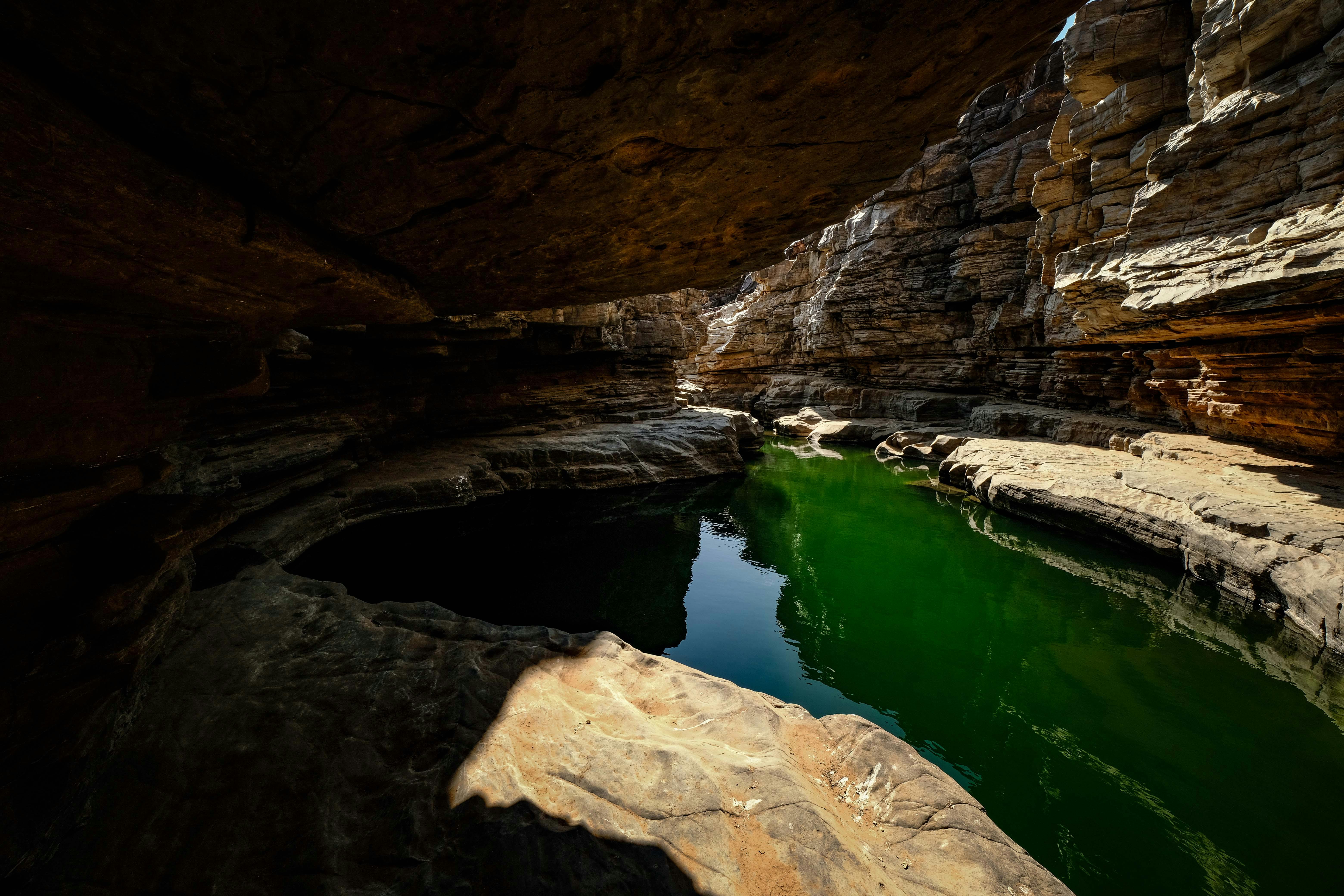 a small pool in a cave surrounded by rocks