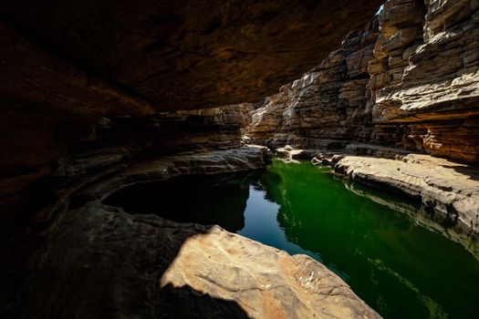 Explore the enchanting beauty of a limestone cave with a serene reflection pool beneath.