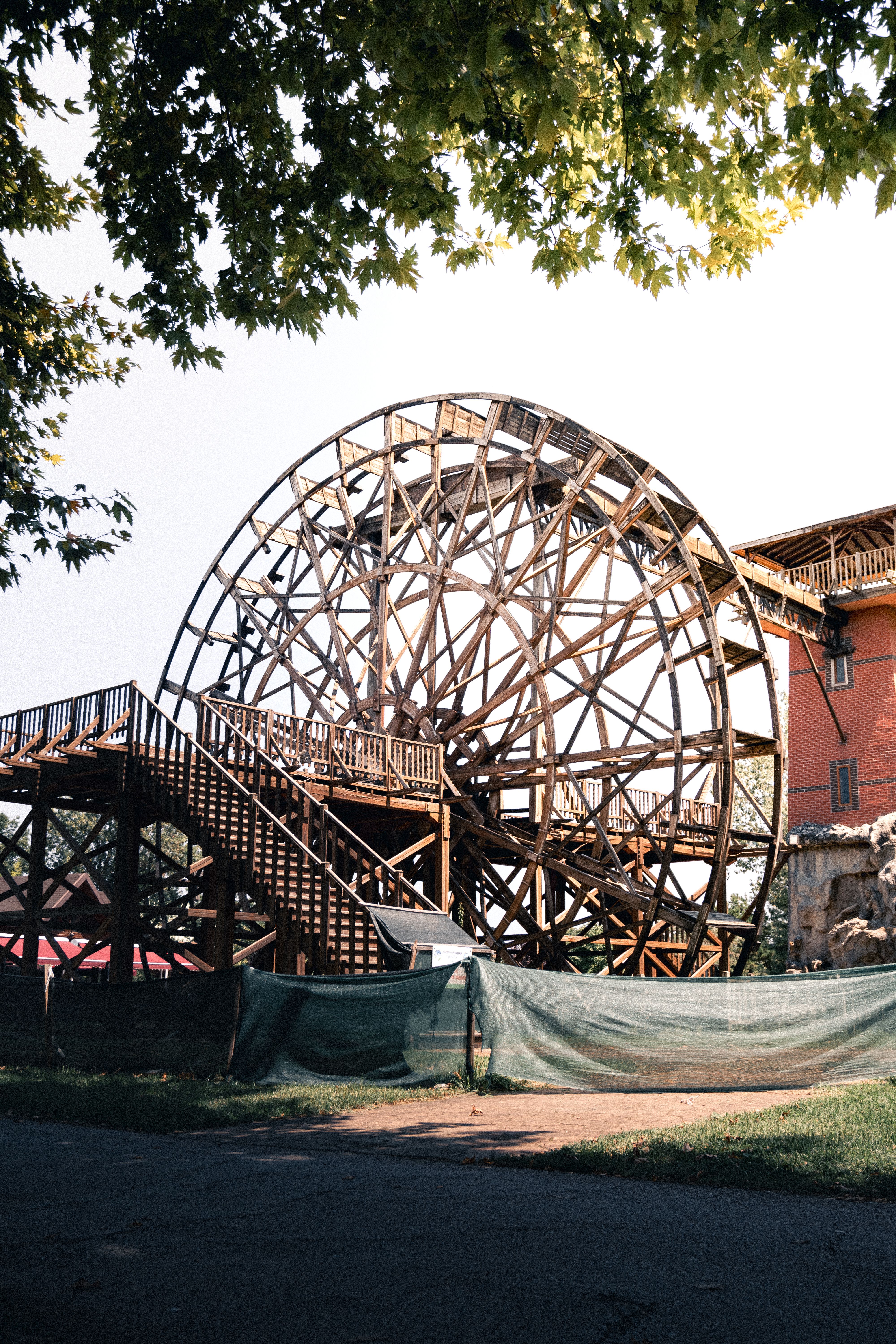 A large wooden wheel is being built in front of a building · Free Stock ...