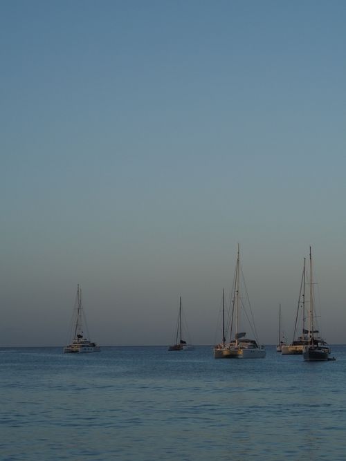 Free Calm sailboats floating on a serene ocean during sunrise in Holetown, Saint James, Barbados. Stock Photo
