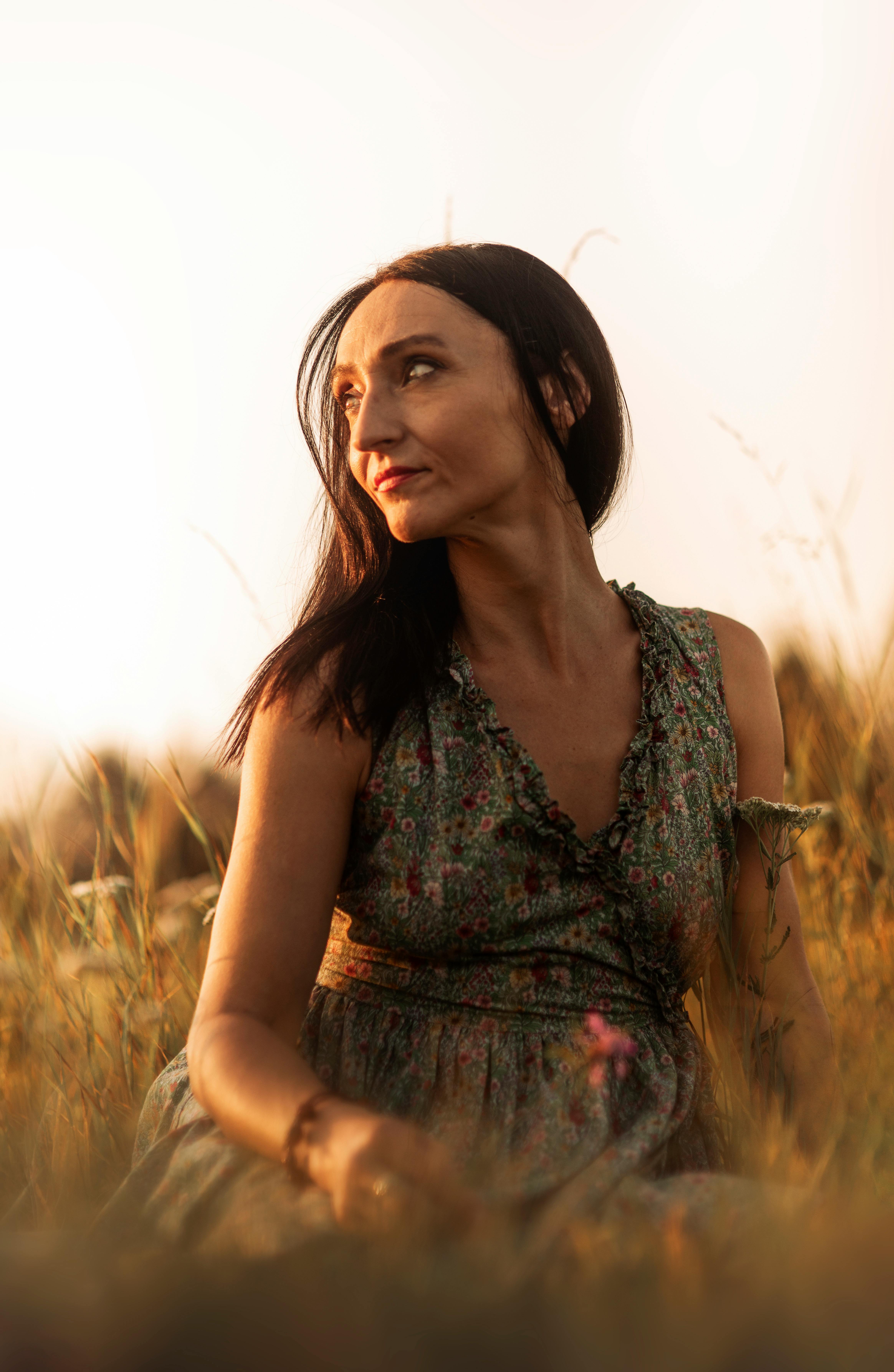 Woman in Brown Floral Dress Walking Near Fence · Free Stock Photo