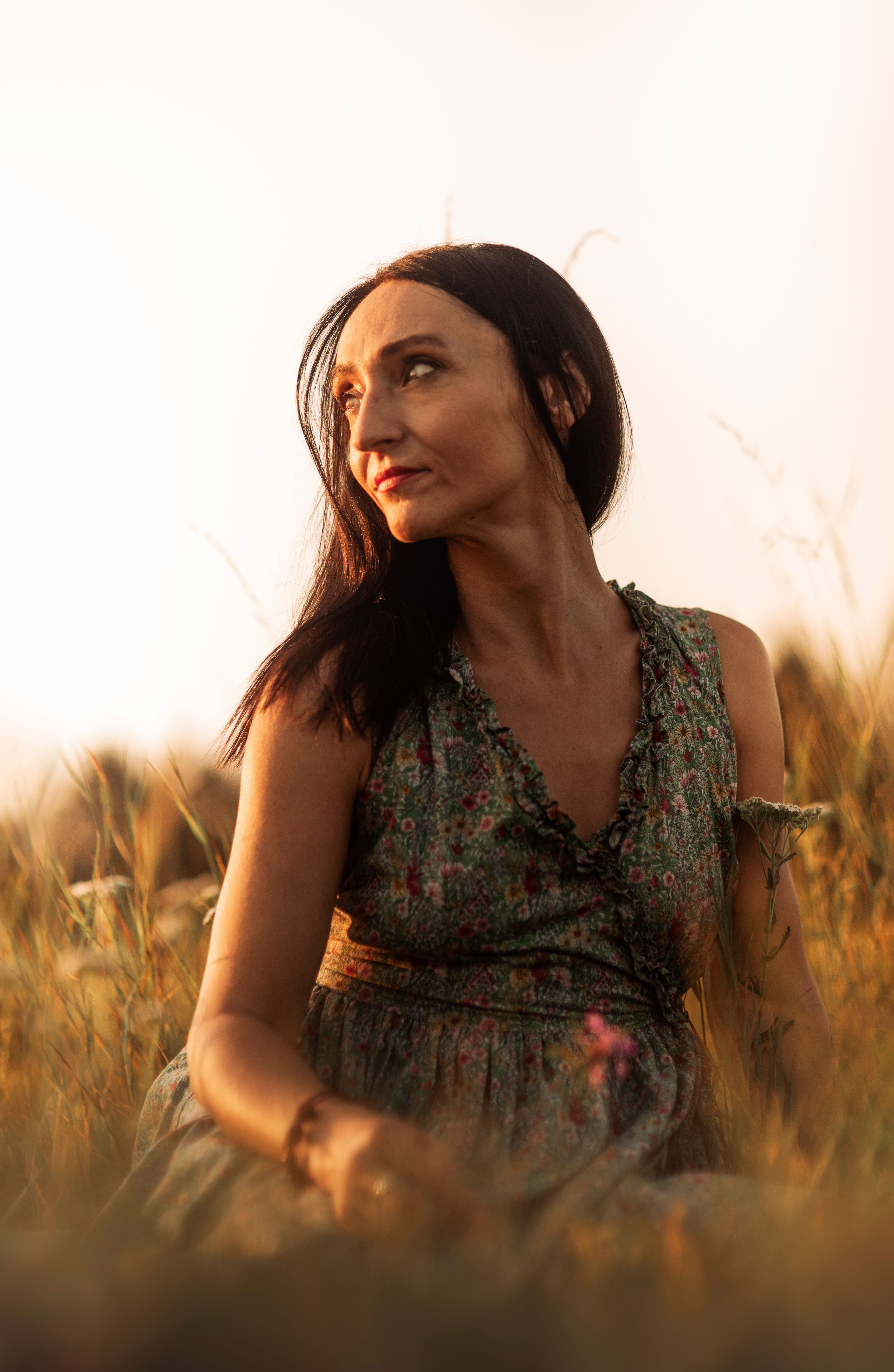 A woman in a dress sitting in a field · Free Stock Photo