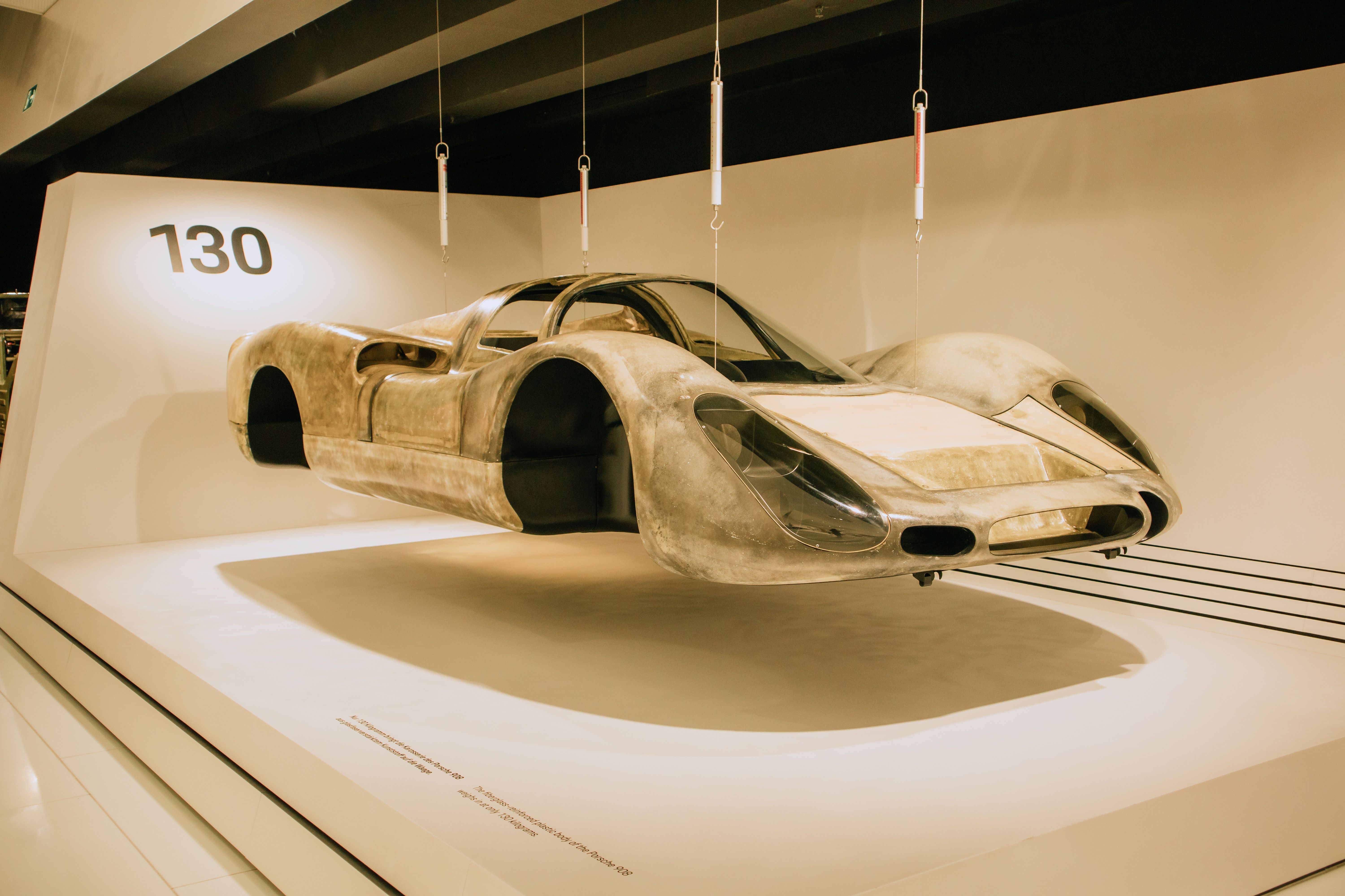 A classic car with sleek design showcased in a modern museum exhibition.