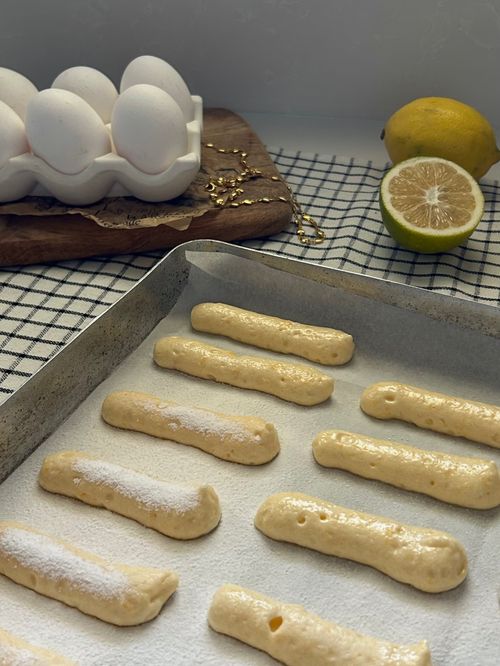 Free Homemade ladyfingers ready for baking, featuring fresh lemon and eggs for a perfect dessert. Stock Photo