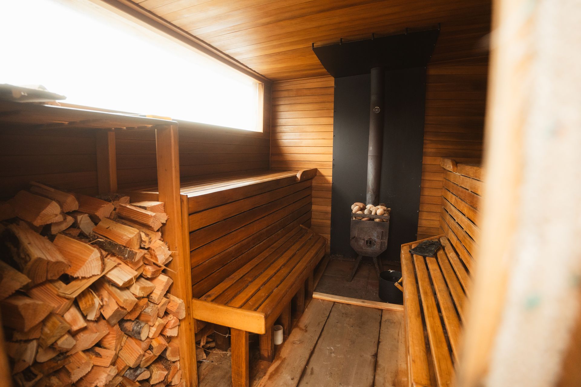 A wooden sauna with logs and benches