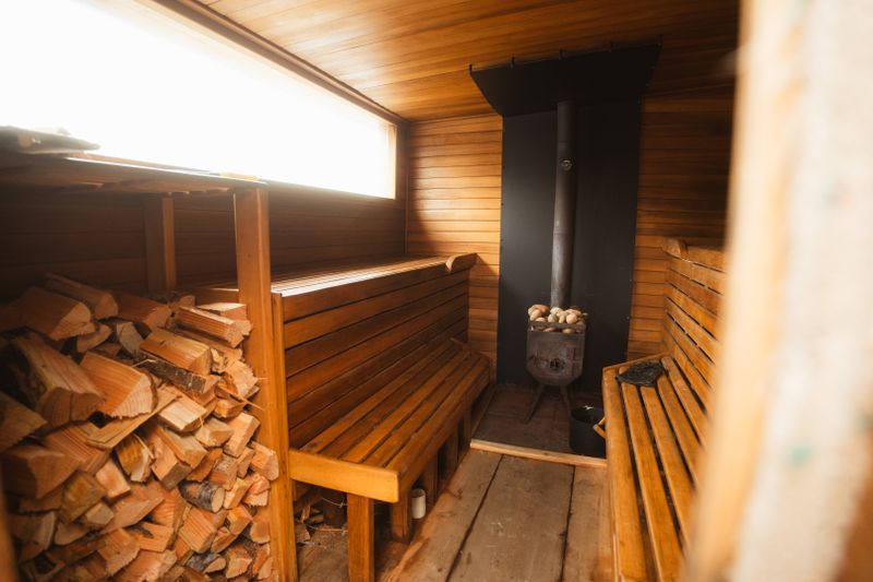 Warm wooden sauna interior with benches and fireplace