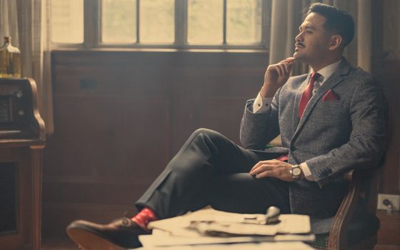 A man in a suit and tie sitting in a chair