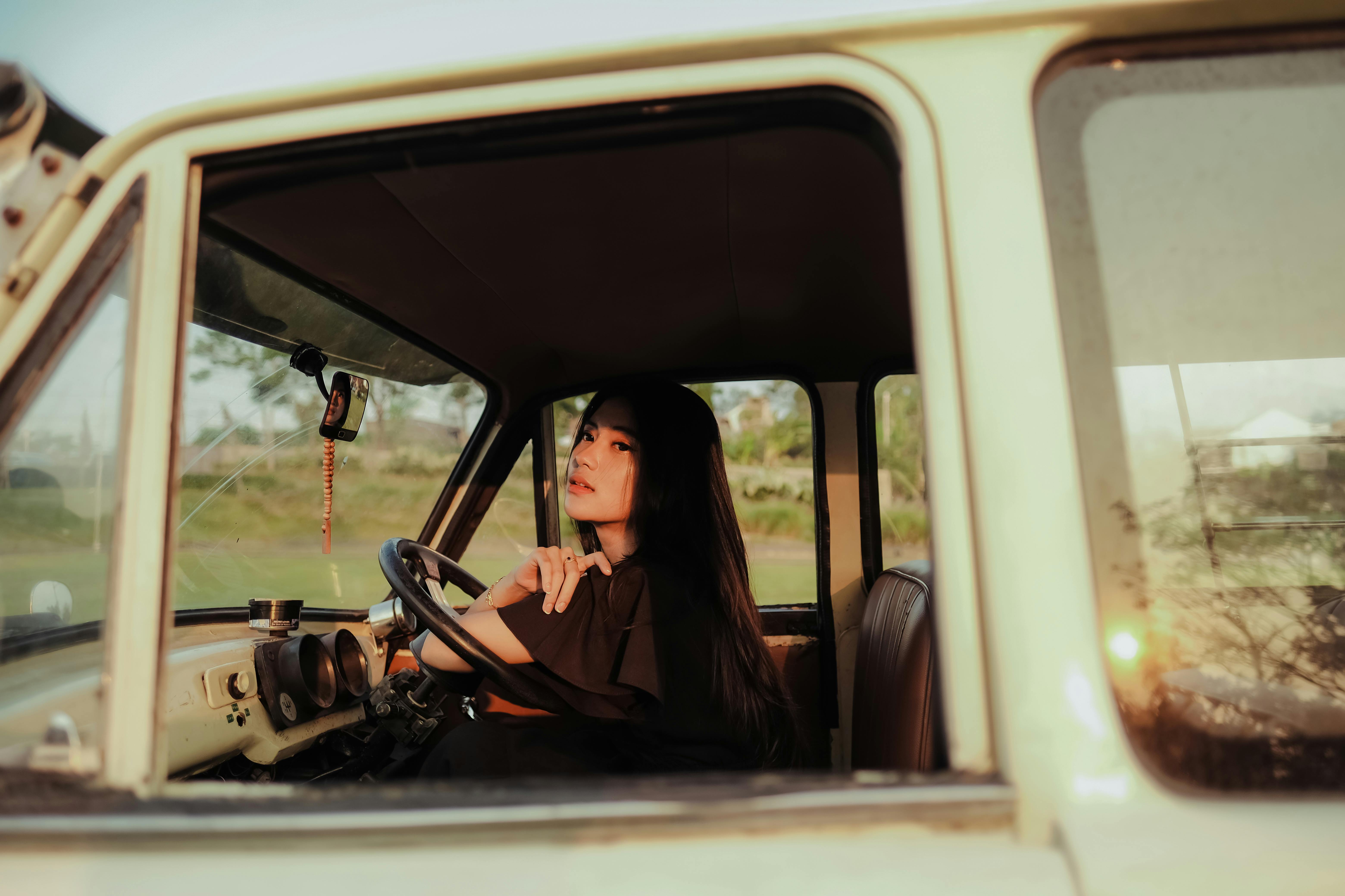 a woman driving a car in the sun