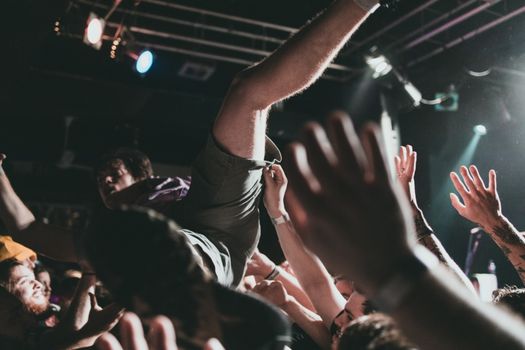 Vibrant scene of a crowd surfer at a live music concert, capturing the thrilling atmosphere.