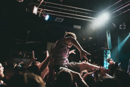 Free Dynamic scene of crowd surfing at a lively concert performance, capturing the excitement of live music. Stock Photo