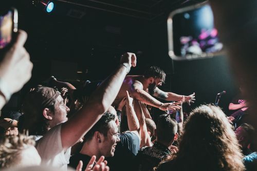 Free Vibrant concert scene with a musician crowd surfing under stage lights. Stock Photo