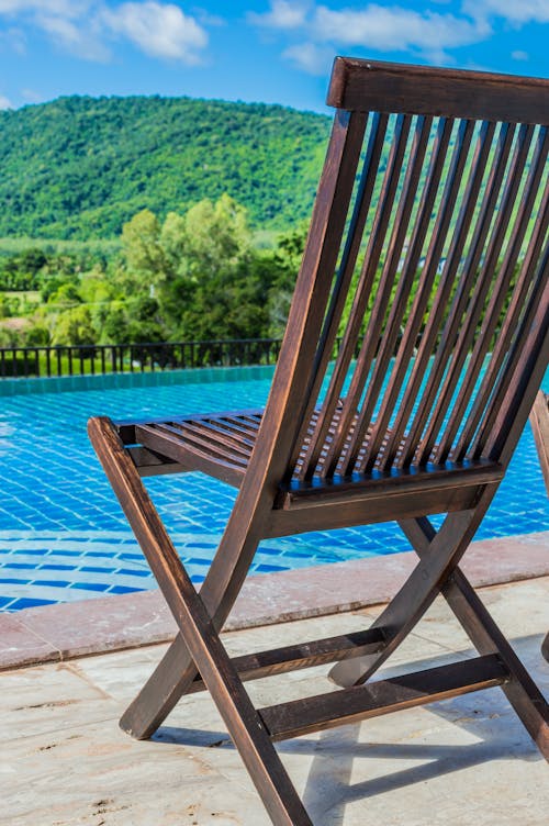 Brown Wooden Deck Chair in Front of Pool