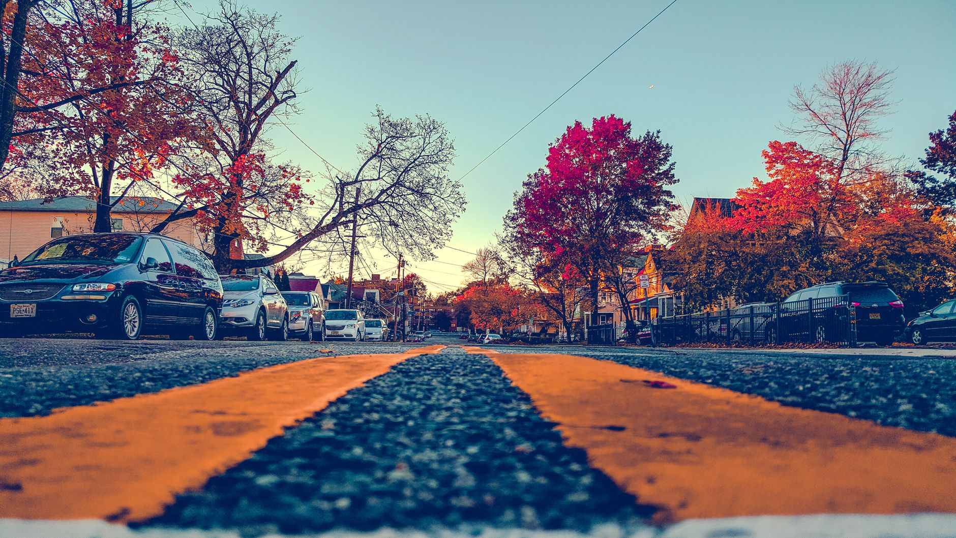 Vibrant autumn street view in Hackensack, NJ with cars and fall foliage.